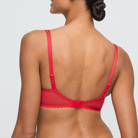 Red bra worn by a model on a plain background
