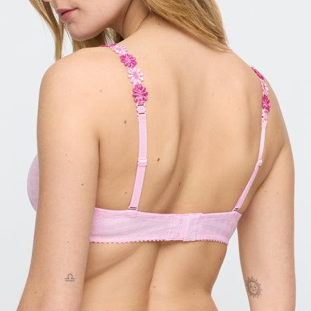 Pink bra with floral straps worn by a model on a plain background