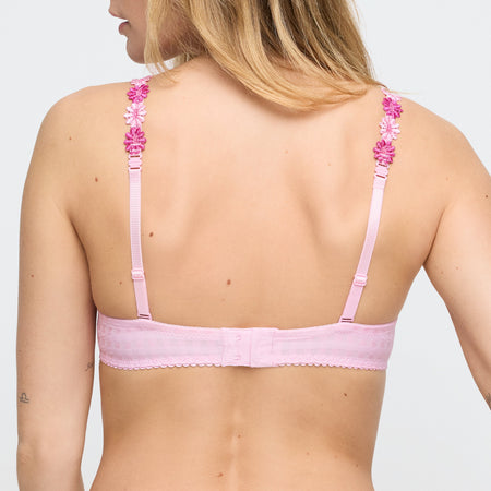 Pink bra with floral straps worn by a model on a light gray background