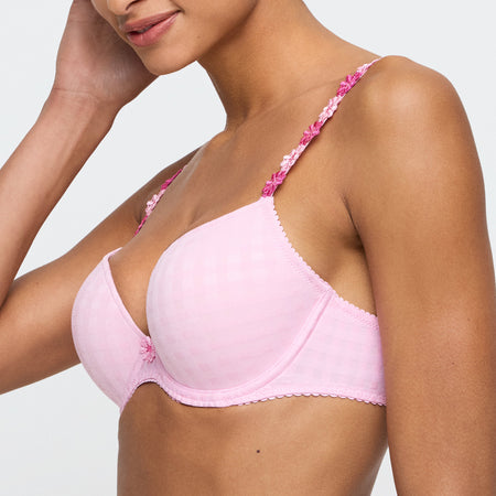 Pink bra with floral straps worn by a model on a plain background