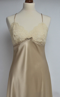 Full length pure silk satin nightgown. The bust line is composed of sheer honey lace. Full length in a heavy silk satin, there is a slit to the side for ease when sleeping. The nightdress is cut on the bias for full movement. The rouleau straps give an extra finesse to this delightful nightgown. 